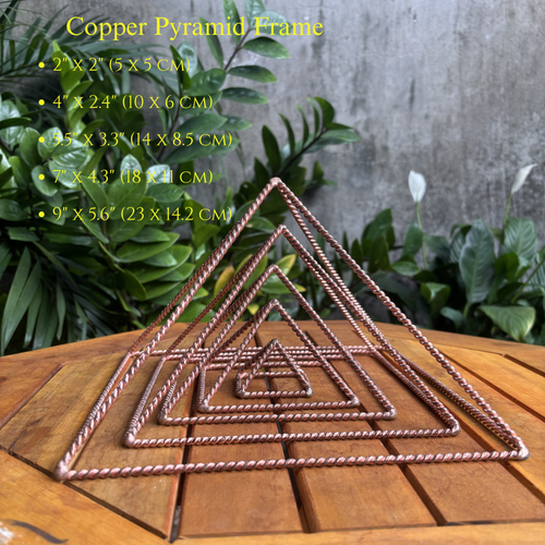 Five handmade copper pyramid frames nested by size on a wooden table, with a size chart from 5 to 23 cm