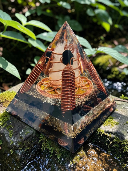 Kim tự tháp năng lượng Lost Cubit Tensor Rings làm từ đồng nguyên chất, có các vòng dây đồng xoắn ốc và đá bên trong, đặt trên đá phủ rêu.