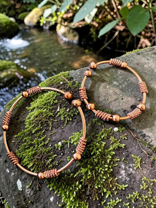 Vòng đeo tay năng lượng Terra Flow bằng đồng nguyên chất, thủ công tinh xảo, màu đồng, có các hạt và dây xoắn trang trí.