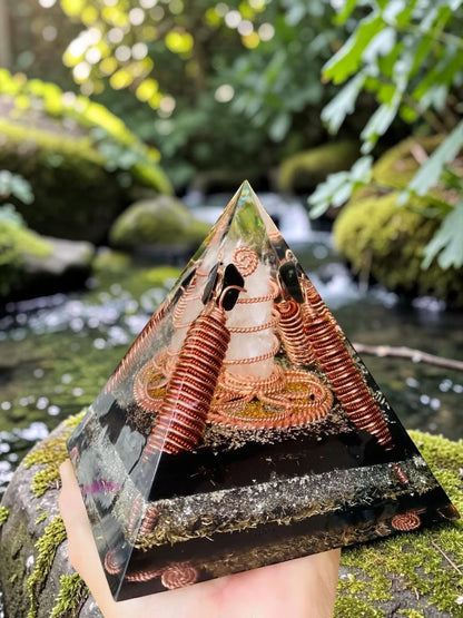 Kim tự tháp năng lượng abusta.viking làm từ đồng nguyên chất, chứa các vòng dây đồng xoắn và đá thạch anh trắng, đặt trên đá phủ rêu.