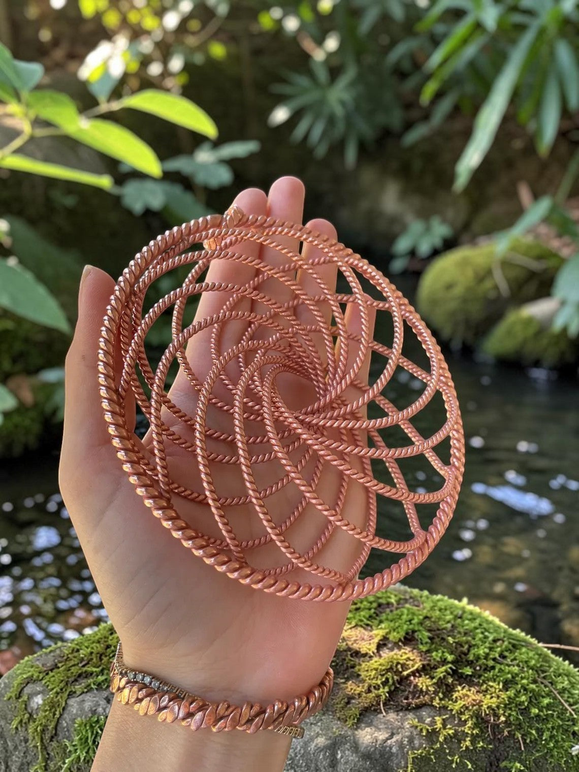 abusta.viking Handmade Tensor Wheat Ear Copper energy tool, intricate spiral design, pure copper, held in hand outdoors.