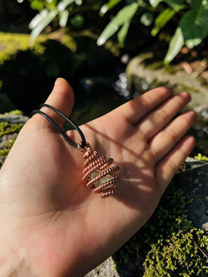 abusta.viking Copper Frequency Comb 144 Mhz Sacred - Pure copper energy tool with spiral cage design, holding a light green crystal.