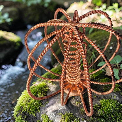 Copper wire sculpture on a rock with a natural background