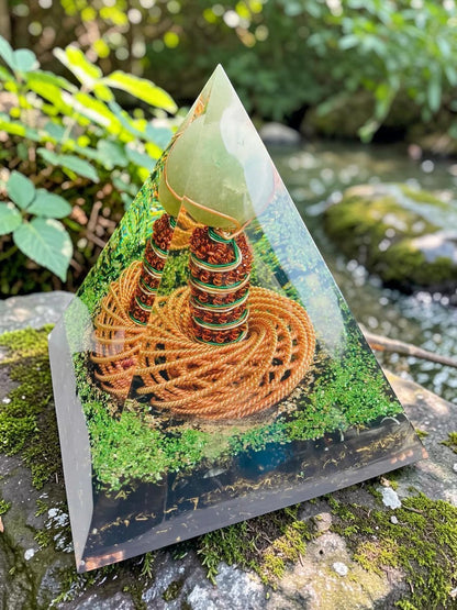 Kim tự tháp orgone abusta.viking với cuộn dây đồng xoắn kép và đá ngọc bích xanh lá cây bên trong, đặt trên đá phủ rêu.
