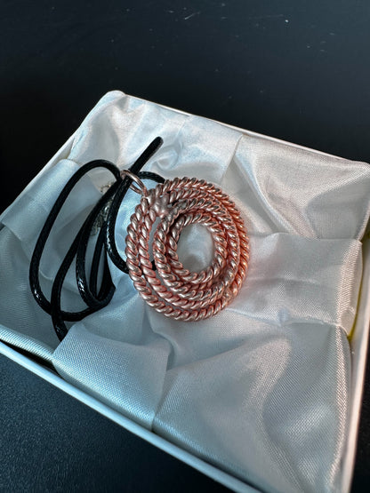 Copper sacred geometry pendant beside its gift packaging, handmade five-frequency tensor necklace
