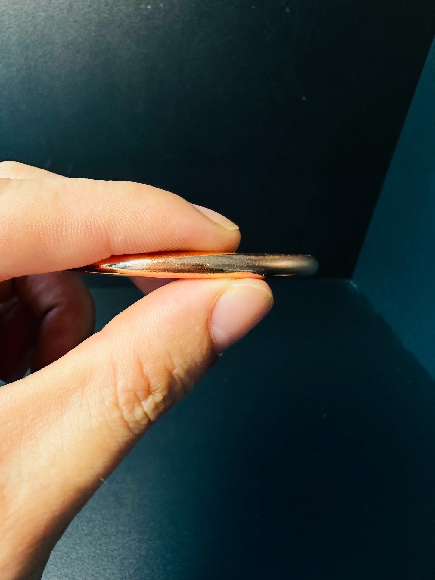 Side view of the copper bangle showing the smooth rounded profile of the band