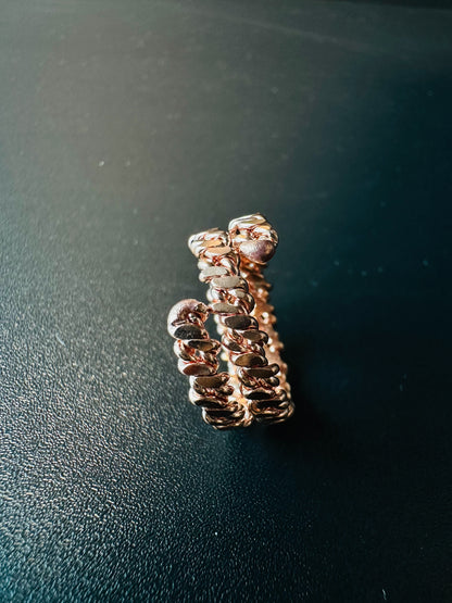 Copper braided ring next to a ruler showing its width and band thickness for sizing reference