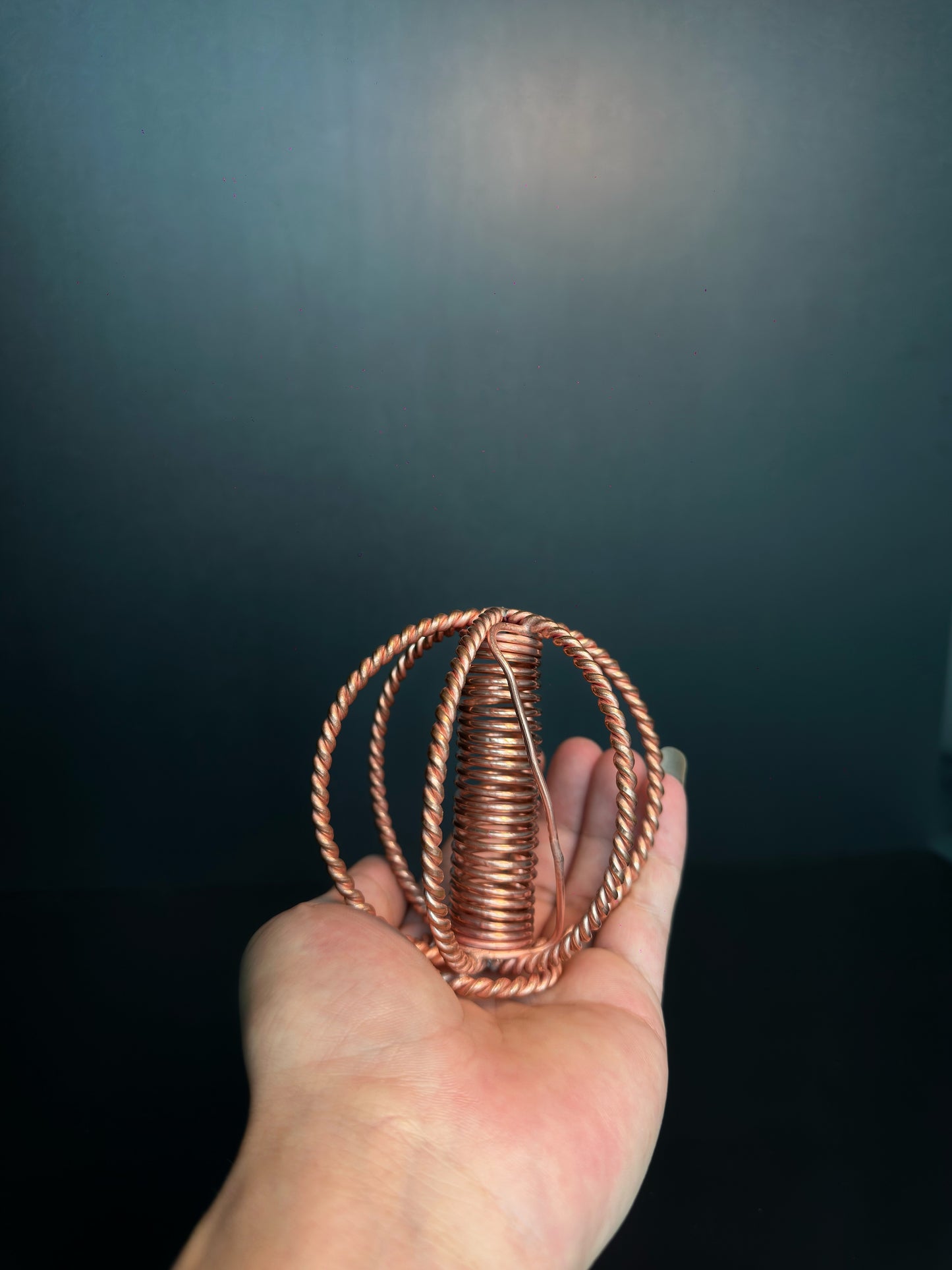 Close-up of wound copper coil core inside the wire sphere