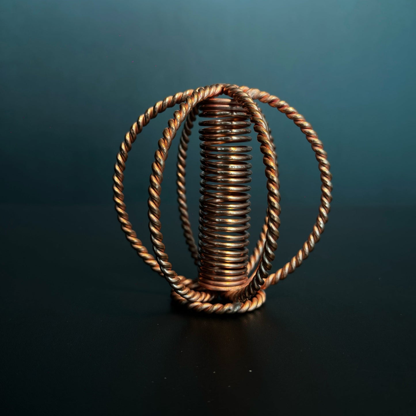 Handmade copper coil sphere with twisted-wire cage and coil core