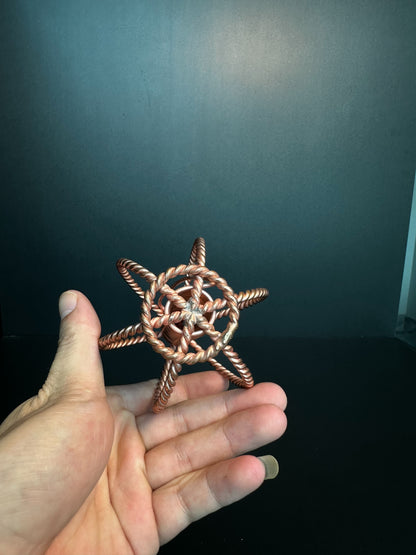 Copper coil sphere held in palm to show its compact size