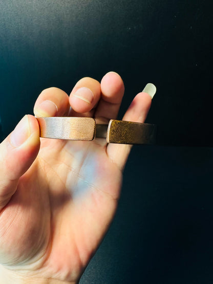 Close-up of the smooth flat ends of the adjustable copper cuff and its thickness