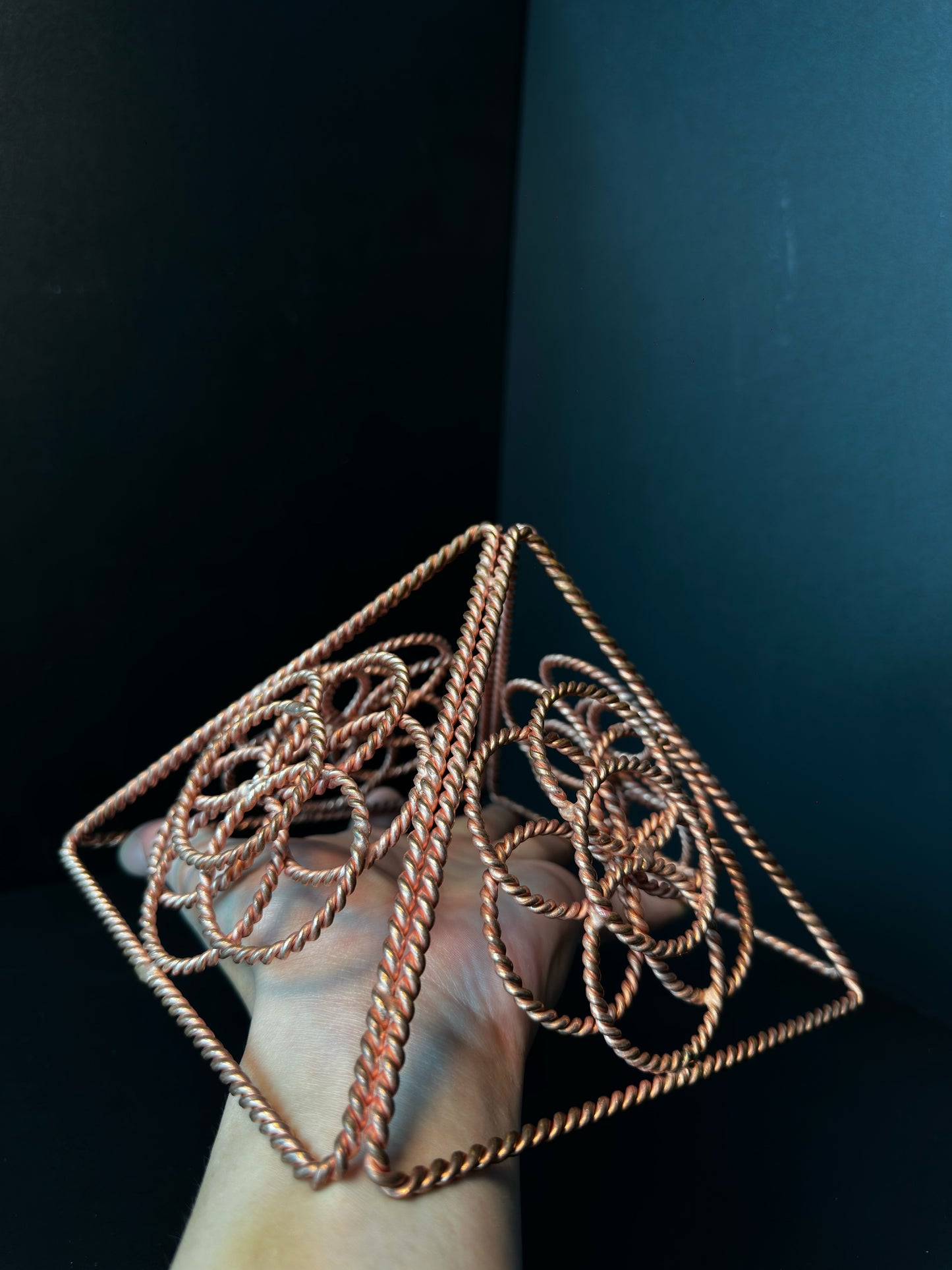 Copper merkaba held in hand showing its hand-sized scale