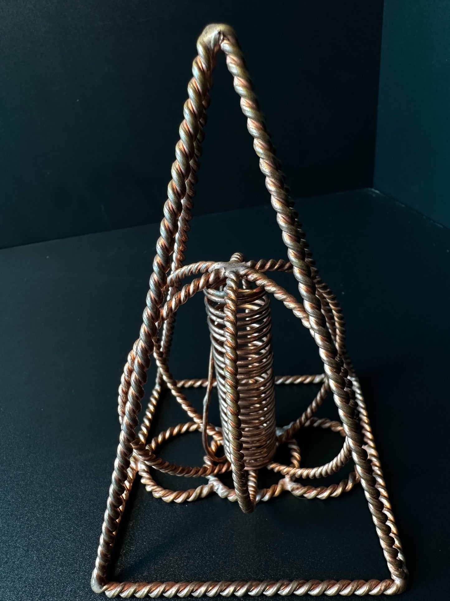 Close-up of the central copper coil framed by the twisted wire pyramid