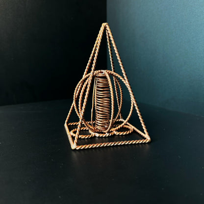 Handmade copper pyramid with a wound copper coil standing at its center