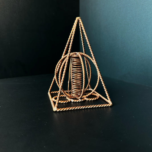 Handmade copper pyramid with a wound copper coil standing at its center