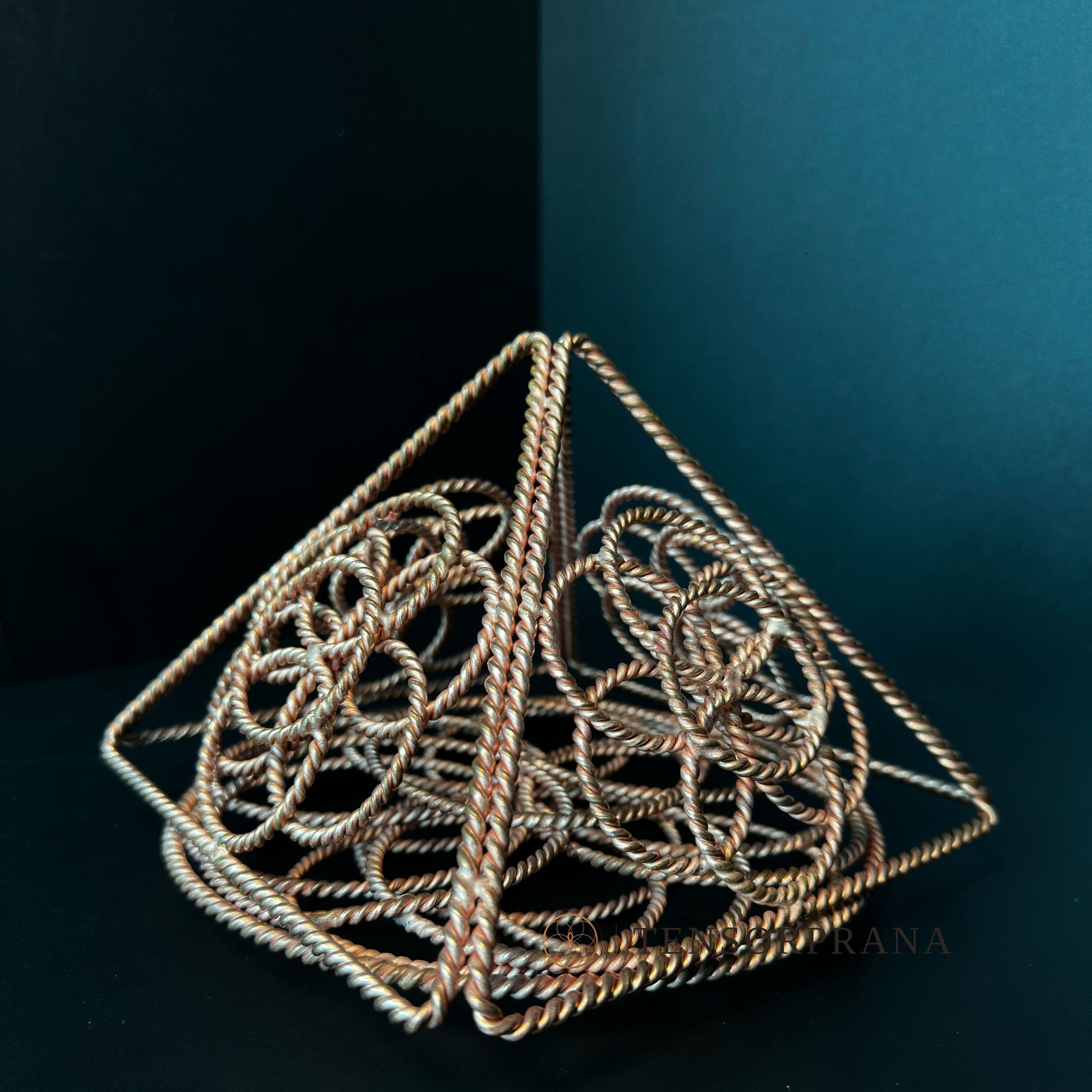 Top-down view of the copper pyramid showing the woven Flower of Life pattern
