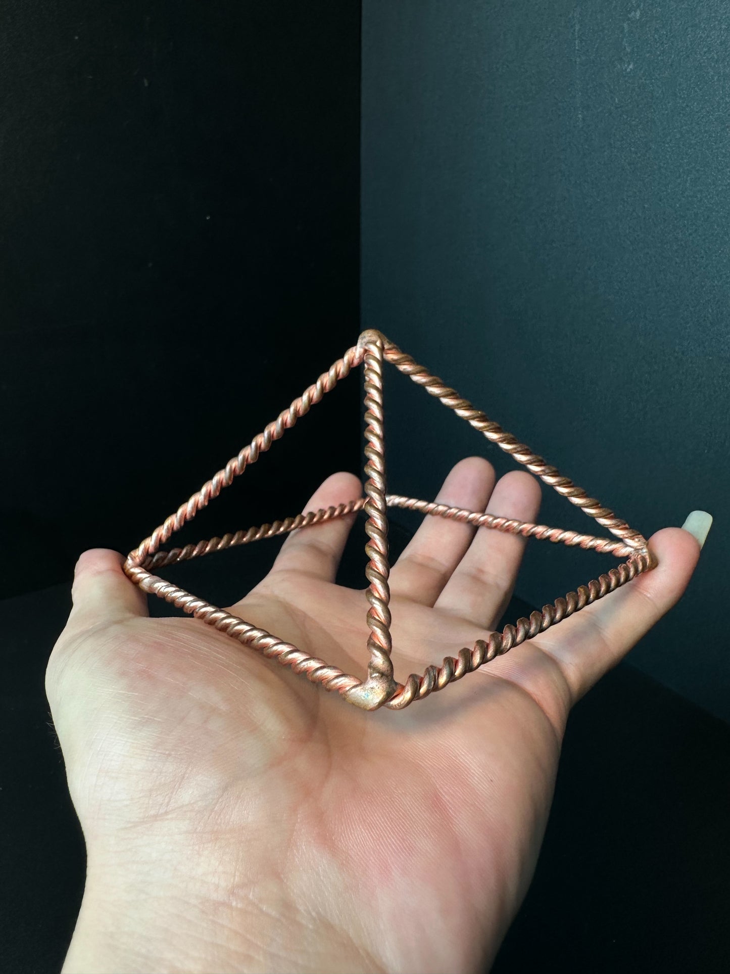 Angled view of open copper meditation pyramid showing apex and base