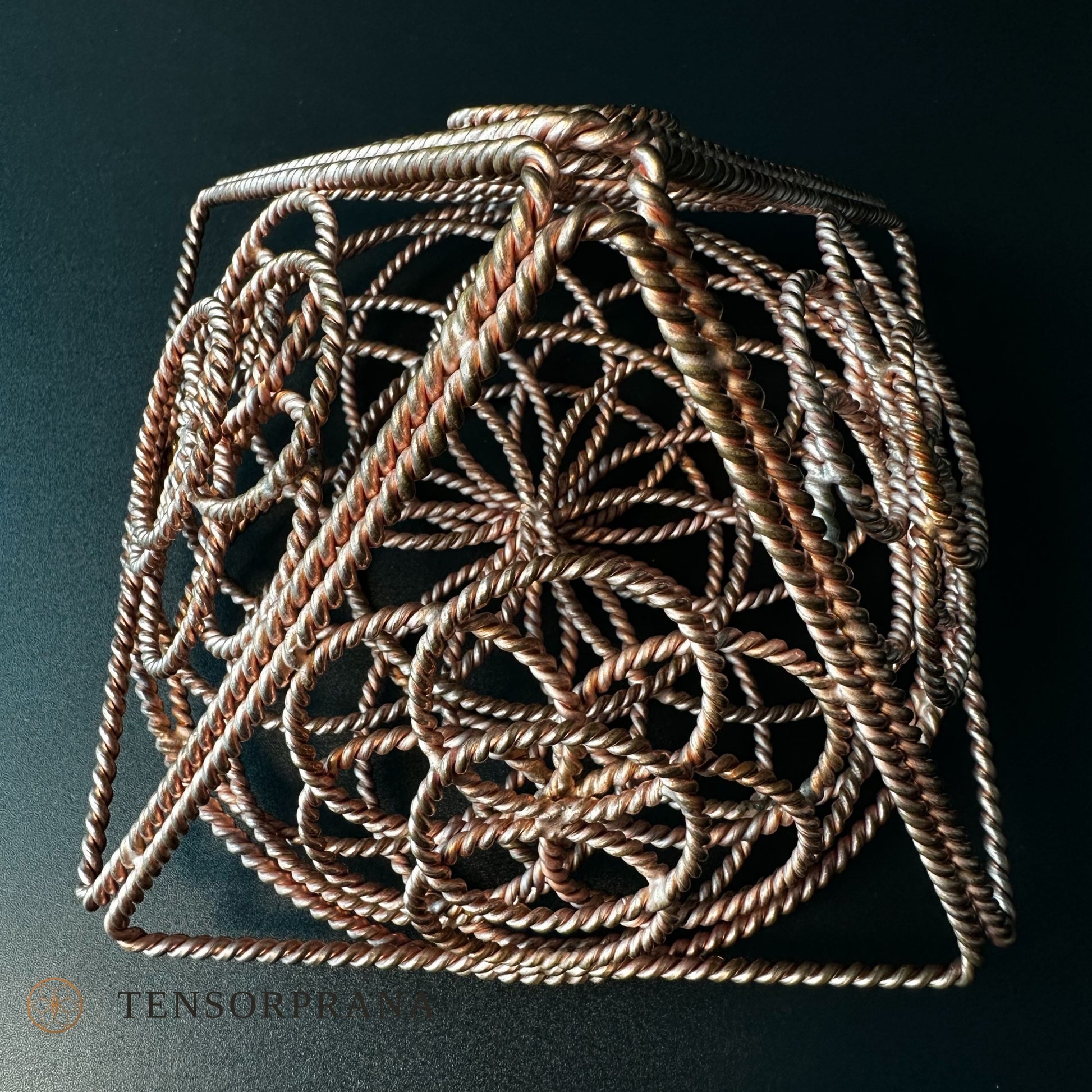 Handmade copper pyramid woven from twisted wire with a Flower of Life pattern inside