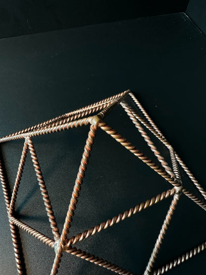 Close-up of hand-twisted copper wire joints, handmade reinforced pyramid detail