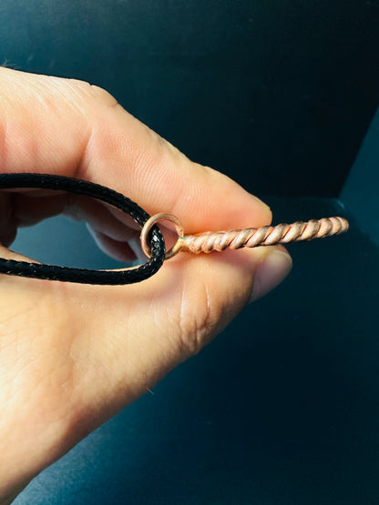 Copper spiral pendant held in hand to show size