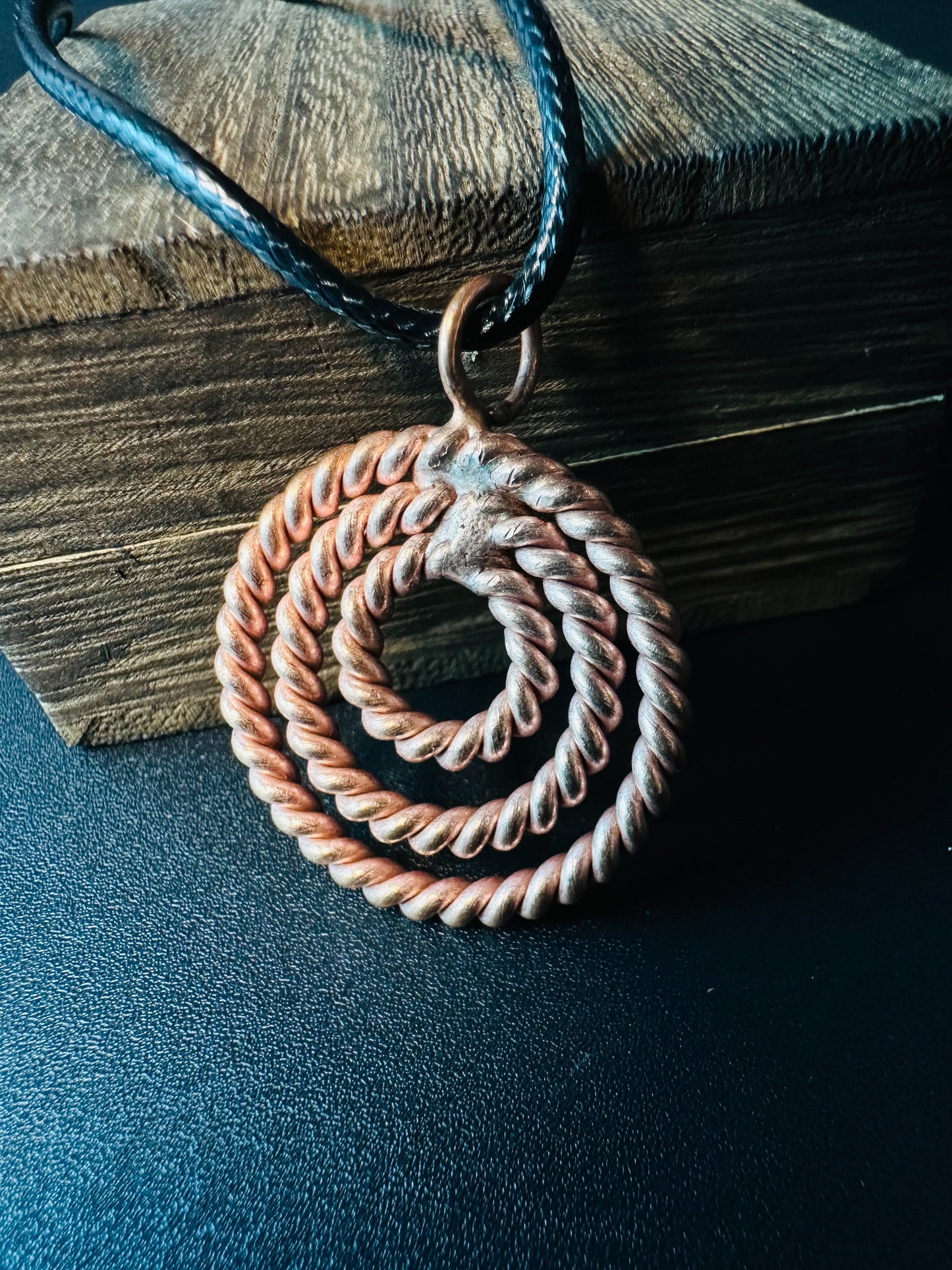 Close-up of hand-twisted copper rope rings forming a spiral