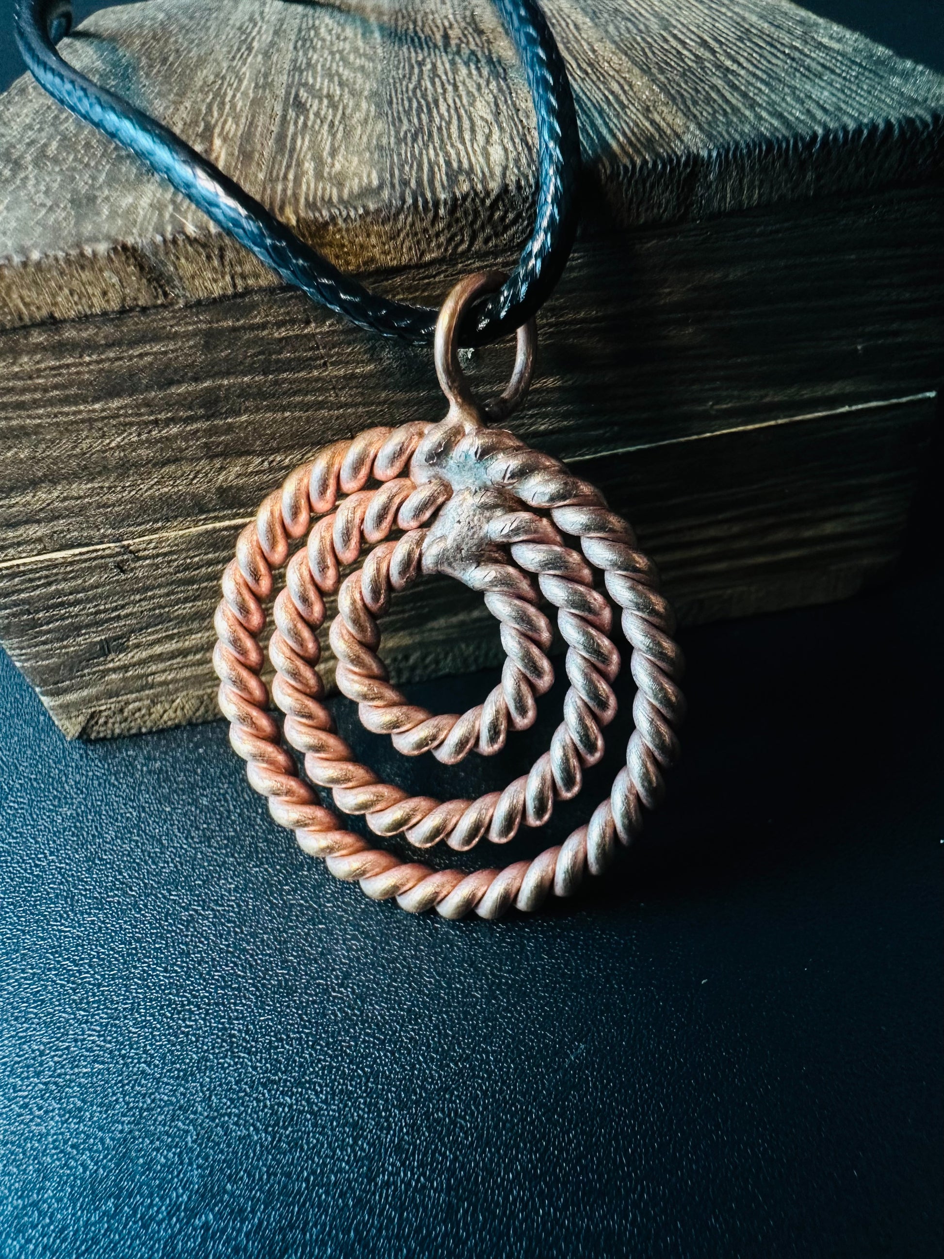 Close-up of hand-twisted copper rope rings forming a spiral