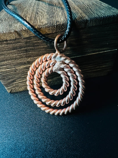 Close-up of hand-twisted copper rope rings forming a spiral