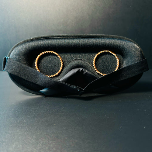 Inside of a handmade copper tensor sleep mask showing two twisted copper rings set over the eye cups