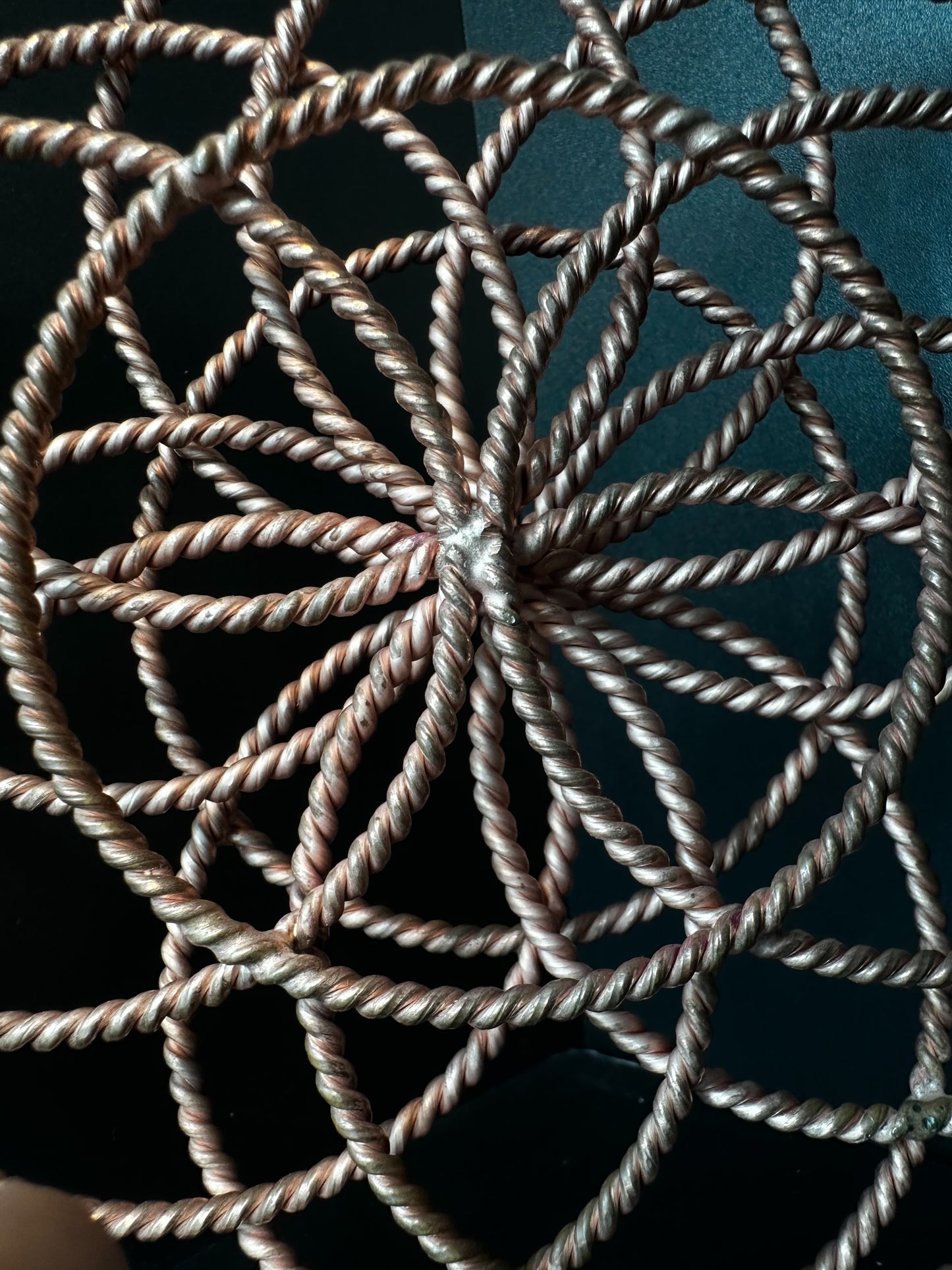 Close-up of the woven copper center where each twisted ring converges at the core