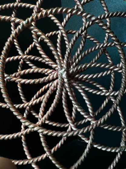 Close-up of the woven copper center where each twisted ring converges at the core