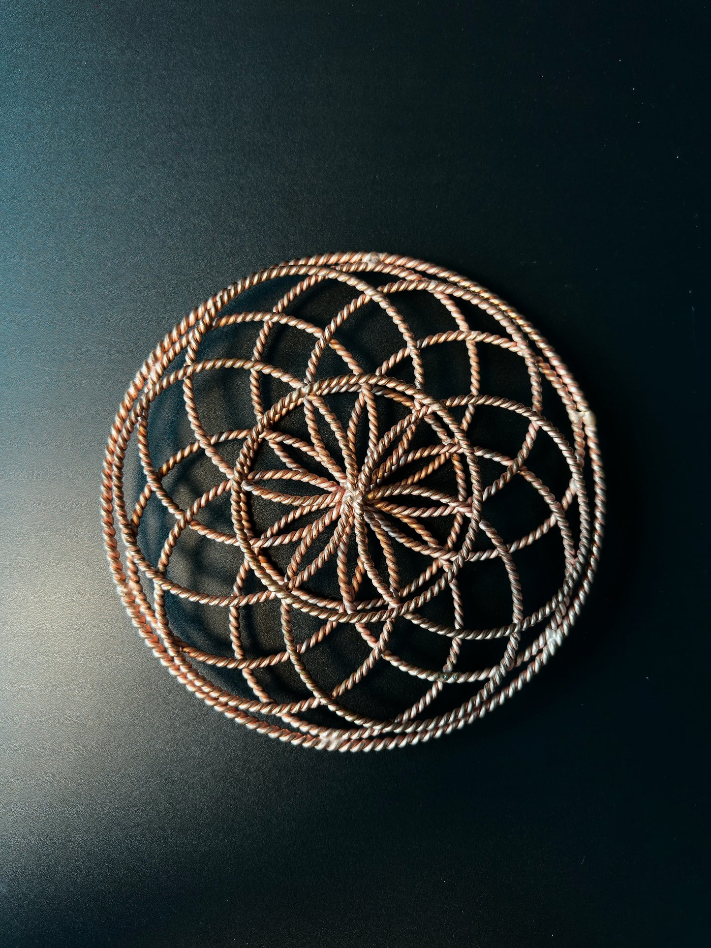 Top-down view showing the Flower of Life pattern formed by the copper rings