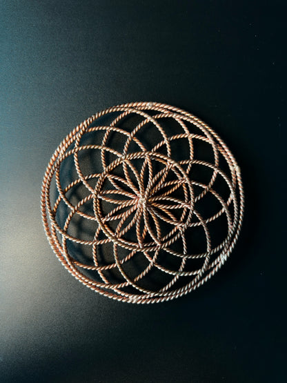 Top-down view showing the Flower of Life pattern formed by the copper rings