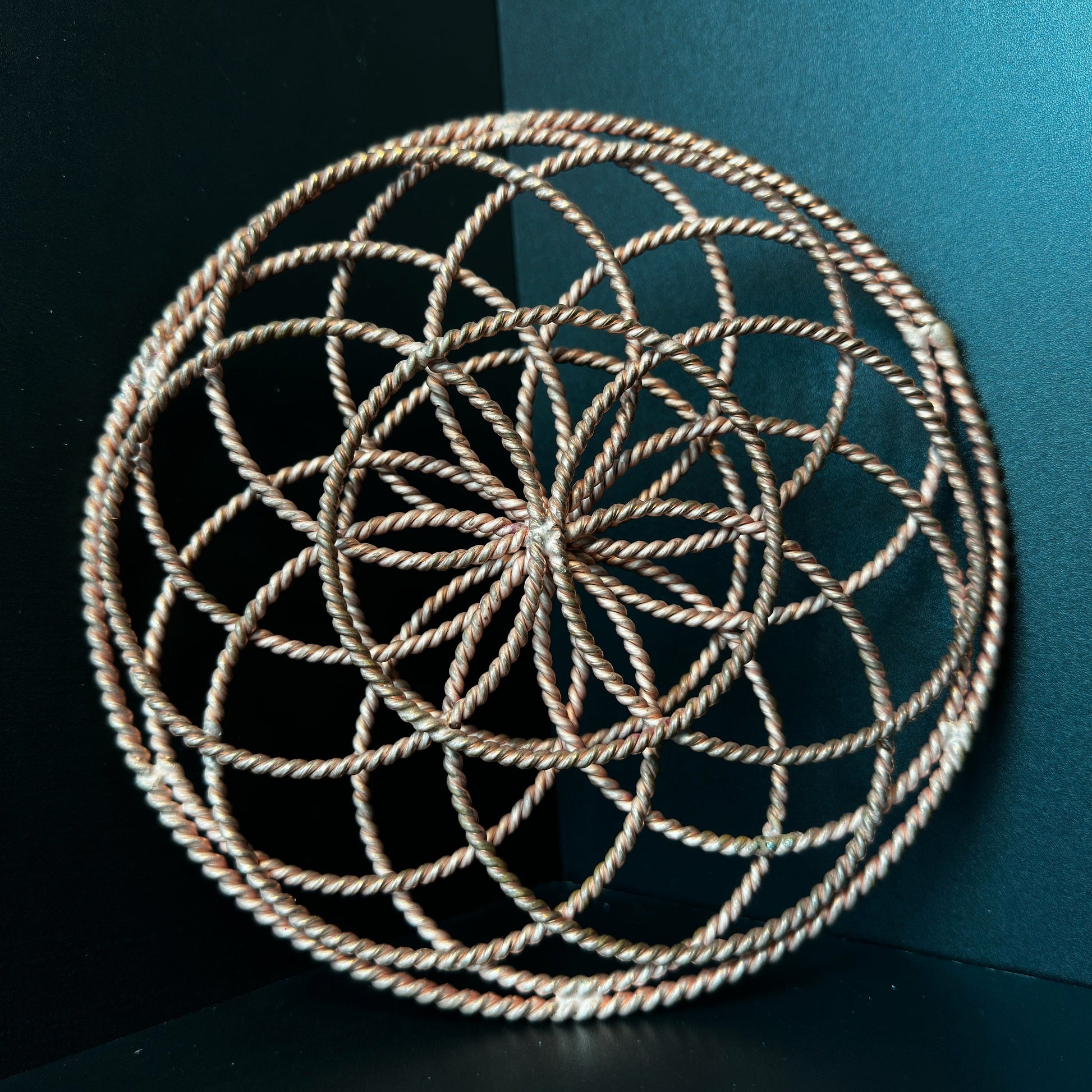 Handmade copper torus sphere woven from twisted rings into a Flower of Life form