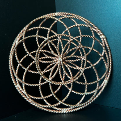 Handmade copper torus sphere woven from twisted rings into a Flower of Life form