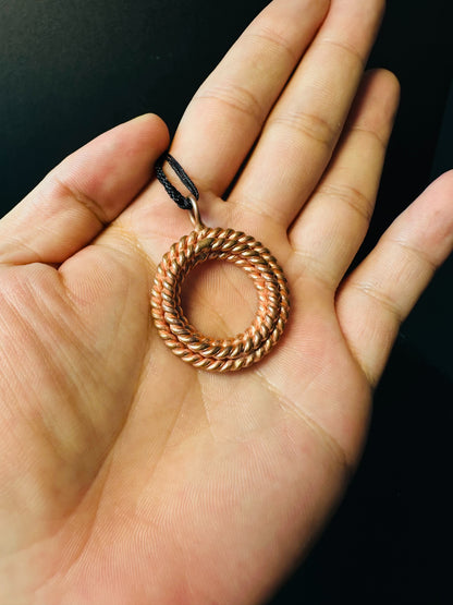 Close-up of twisted copper strands forming a ring pendant