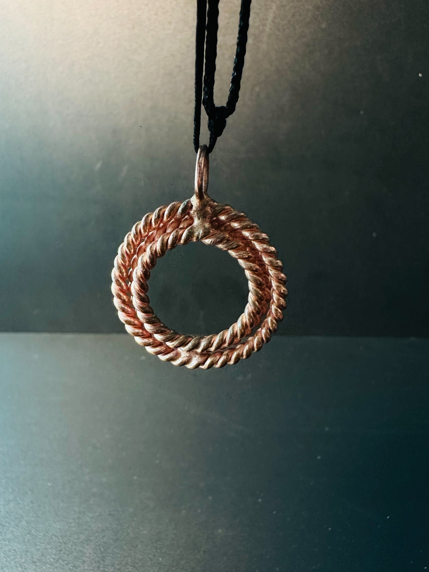 Side profile of copper rope ring pendant showing its thickness