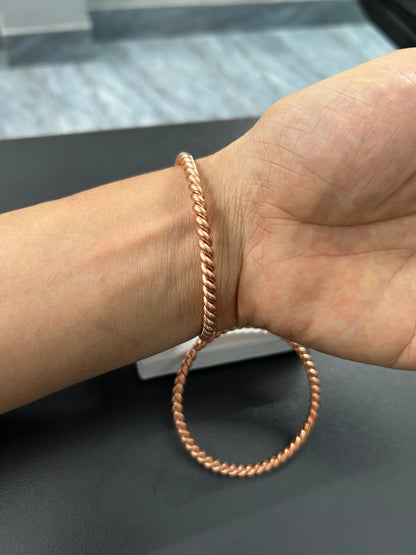 Close-up of twisted rope texture on handmade pure copper bangle, spiral copper detail.