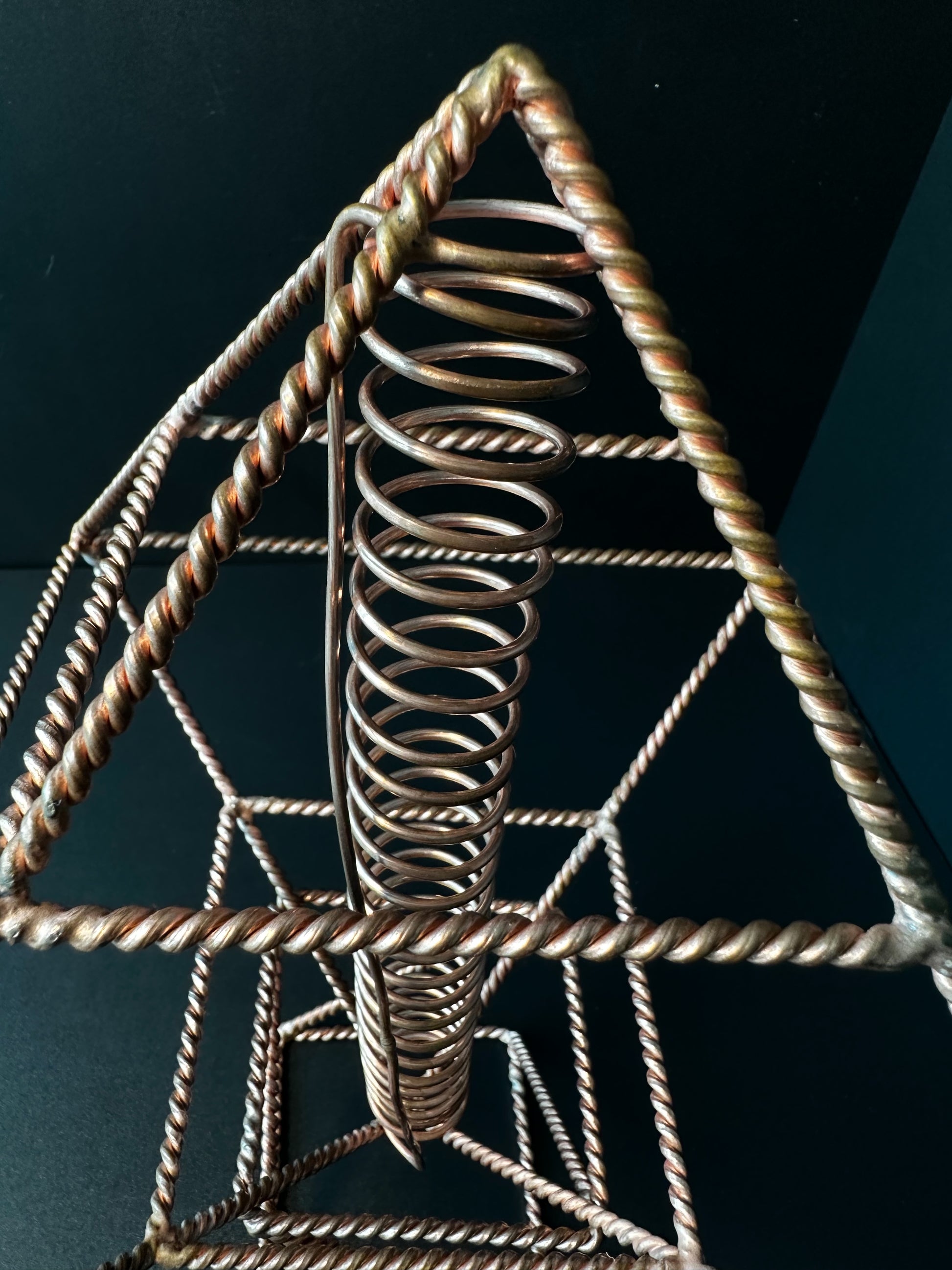 Close-up of copper vortex coil inside octahedron frame, handmade reiki energy generator