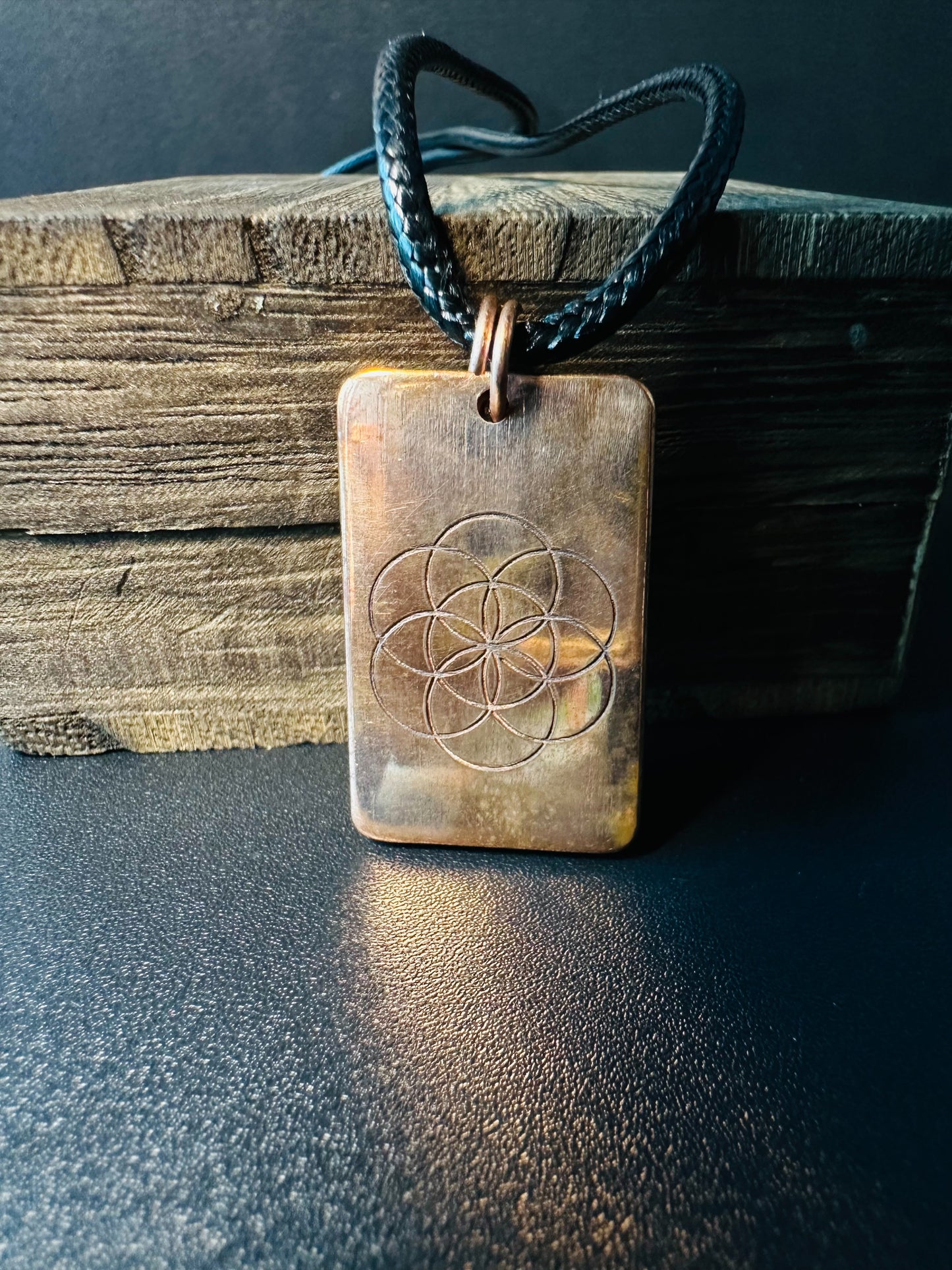 Reverse side of the copper pendant showing the engraved Seed of Life sacred geometry symbol