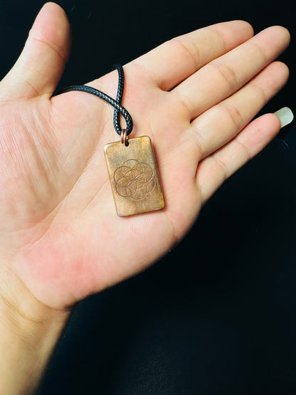Copper Seed of Life pendant resting on a hand, showing everyday-wear scale