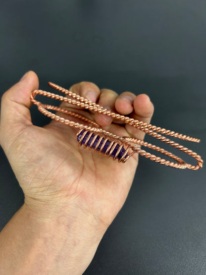 Handmade copper tensor glasses with amethyst crystal held in hand