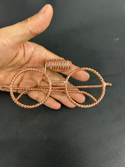 Handmade copper tensor glasses with rose quartz crystal held in hand