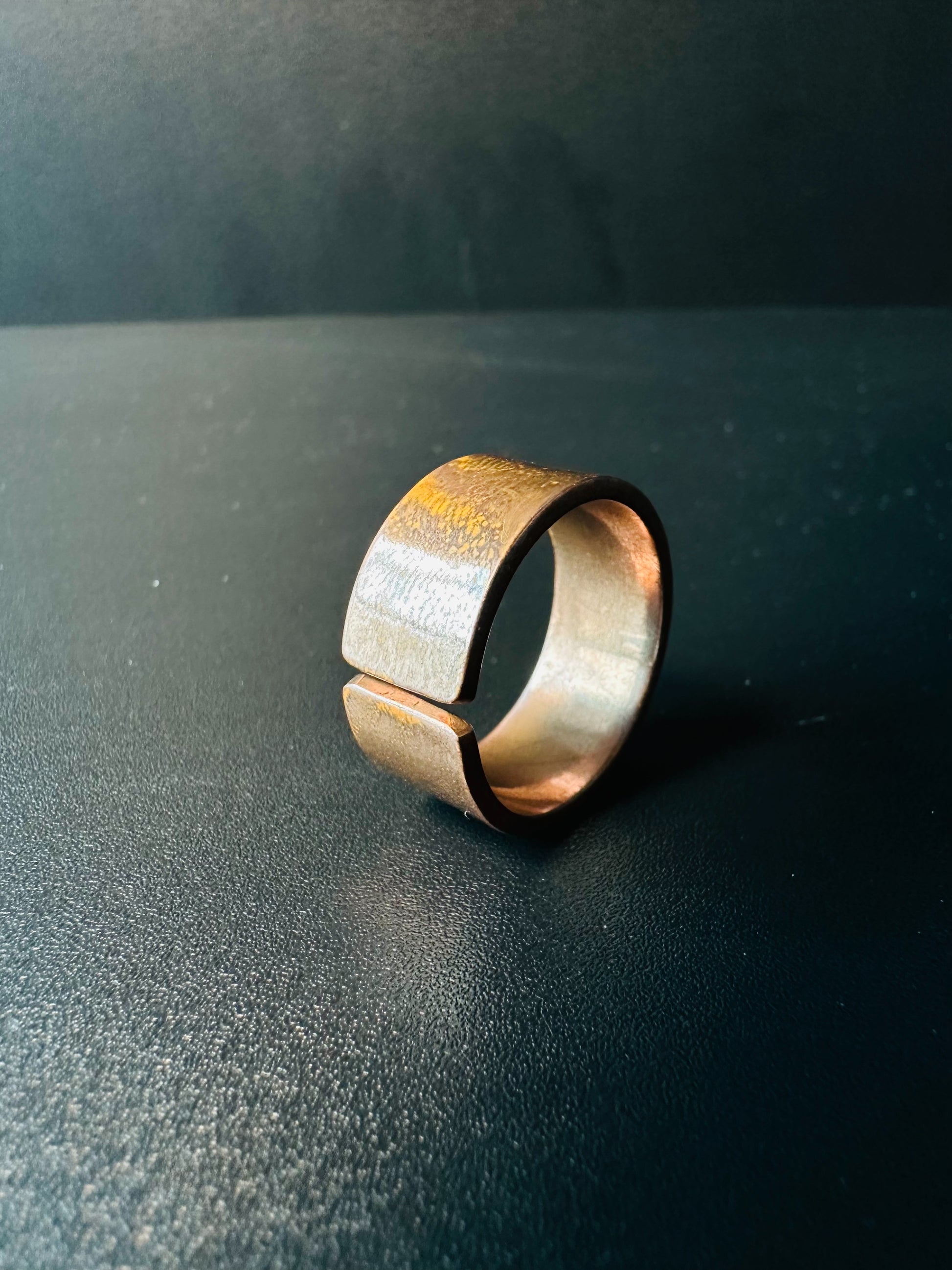 Side view of the open copper band ring showing its adjustable gap and brushed finish