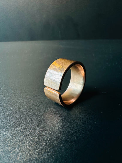 Side view of the open copper band ring showing its adjustable gap and brushed finish