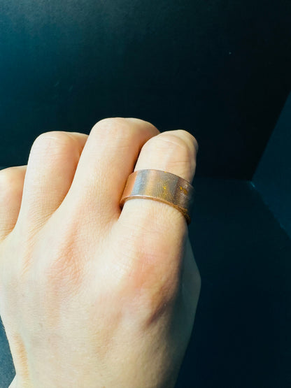 Wide copper band ring worn on a finger, a simple grounding everyday piece